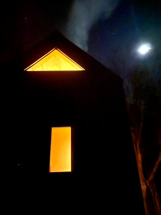 Tiny Belbén terminada, de noche, con ventanas iluminadas